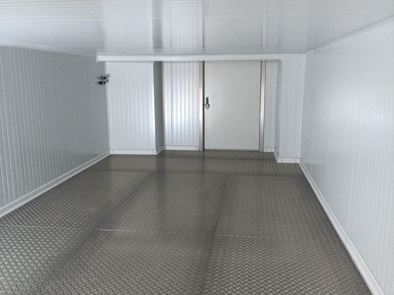 Cámara frigorífica acabada con puerta de acceso y suelo de aluminio antideslizante.